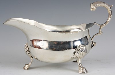 Lot 300 - A GEORGE V SILVER SAUCE BOAT on three shelled...