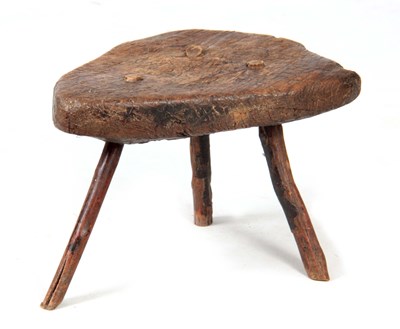 Lot 955 - AN EARLY PRIMITIVE ELM STOOL with a thick-cut...