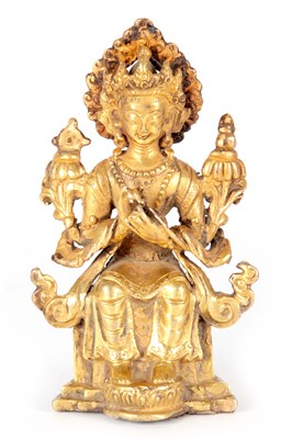 Lot 185 - AN EARLY GILT BRONZE BUDDHA depicting a seated...