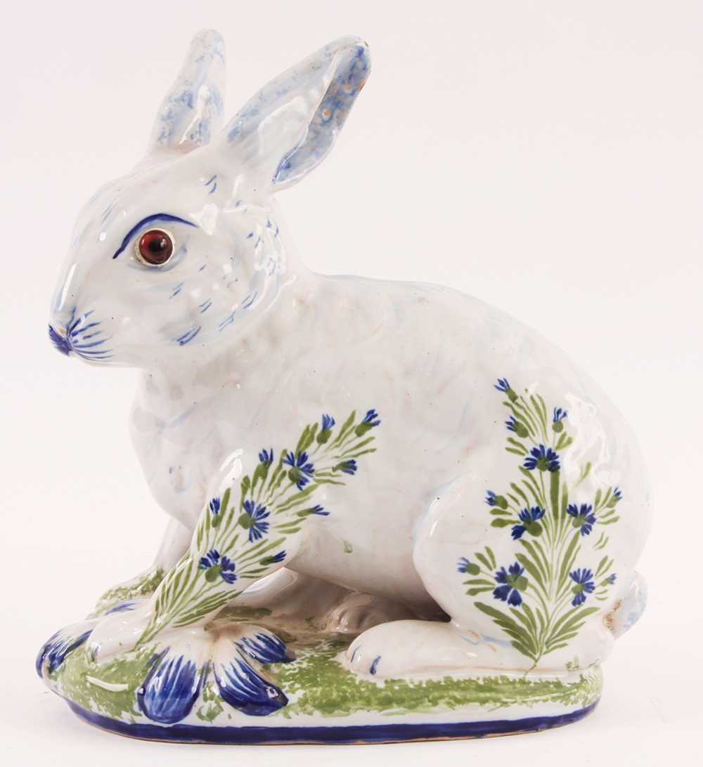 Lot 74 - A DELFT STYLE GLAZED SEATED RABBIT with amber...