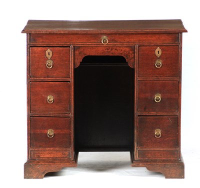 Lot 1075 - A QUEEN ANNE OAK KNEEHOLE DESK the moulded...