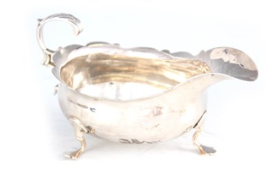 Lot 357 - A GEORGE III SAUCEBOAT with shaped rim and...