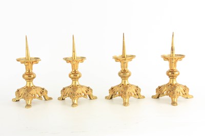 Lot 480 - A SET OF FOUR 19TH CENTURY GILT BRONZE PRICKET...