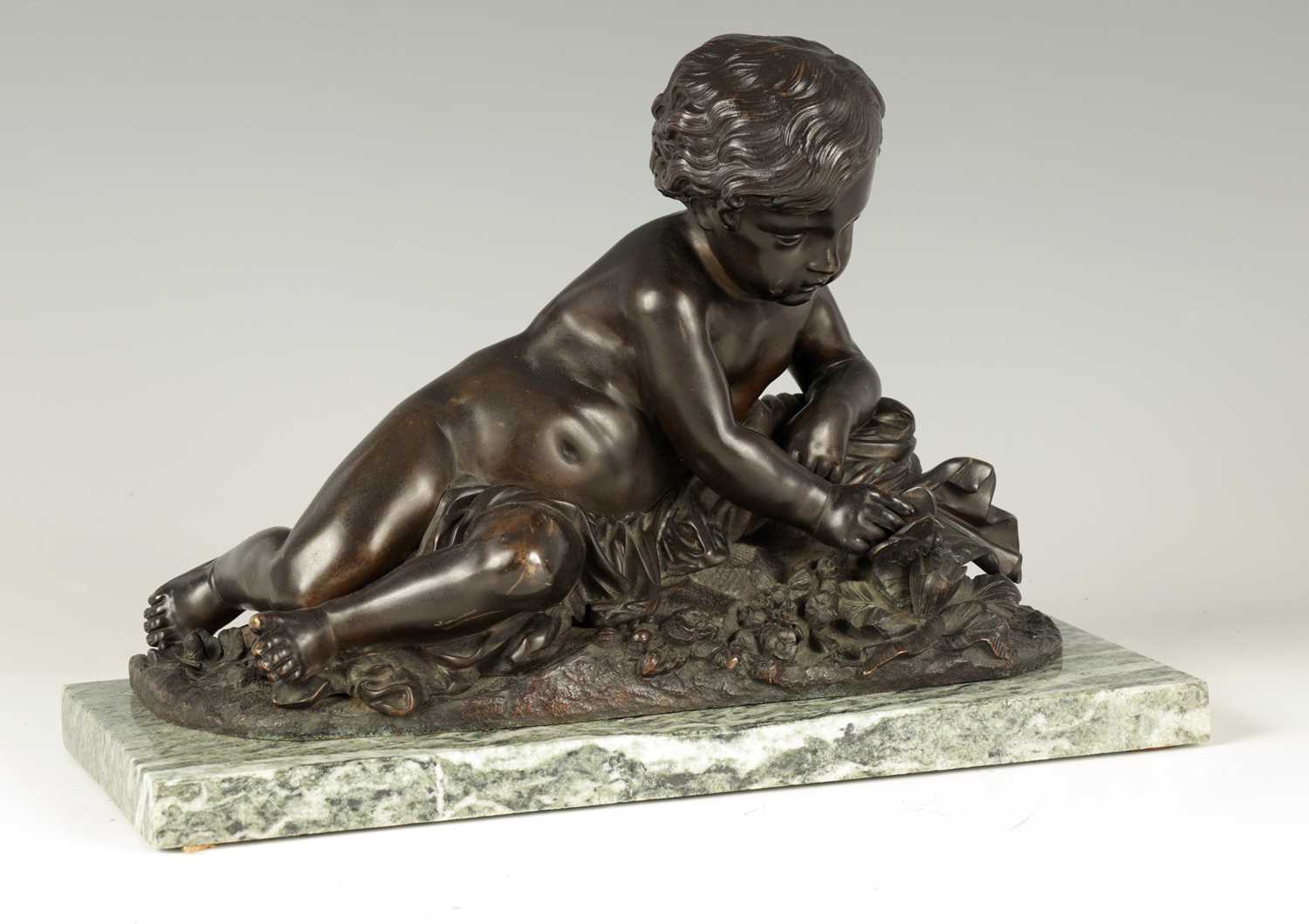 Lot 662 - A 19TH CENTURY BRONZE SCULPTURE OF A SEATED CHERUB HOLDING A BUTTERFLY