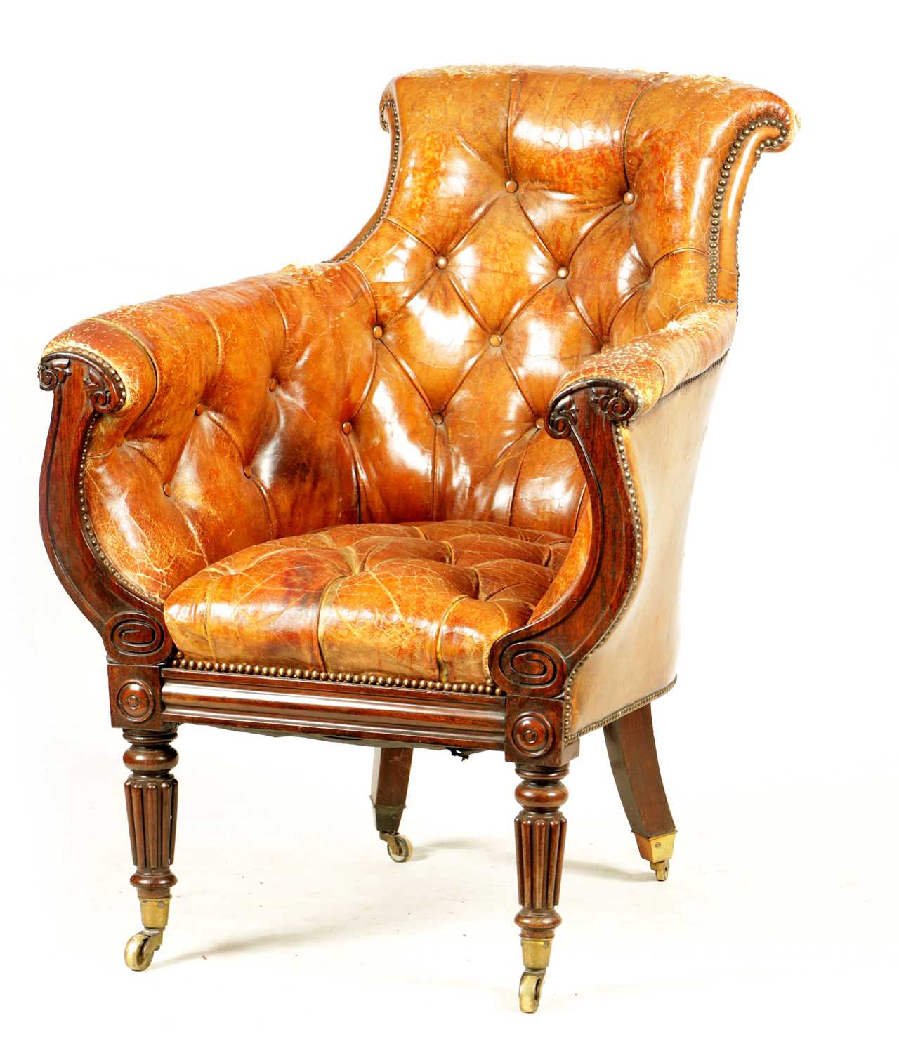 Lot 1027 - A LATE REGENCY ROSEWOOD FRAMED AND STUDDED TAN LEATHER UPHOLSTERED LIBRARY CHAIR