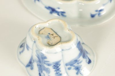 Lot 215 - AN 18TH CENTURY CHINESE KANGXI BLUE AND WHITE SHAPED CUP AND SAUCER