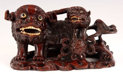 Lot 180 - A CHINESE CARVED HARDWOOD FOO DOG FIGURE with...