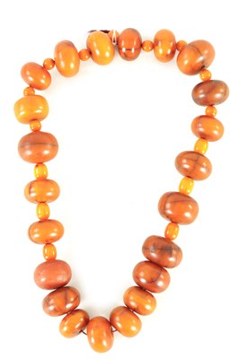 Lot 183 - AN USUALLY LARGE AND SMALLER INTERMITENT STRING OF AMBER BEADS