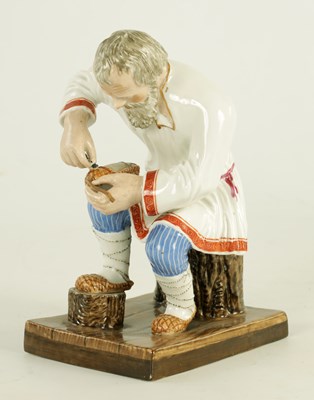 Lot 23 - AN EARLY 20TH CENTURY RUSSIAN PORCELAIN FIGURE DEPICTING A COBLER