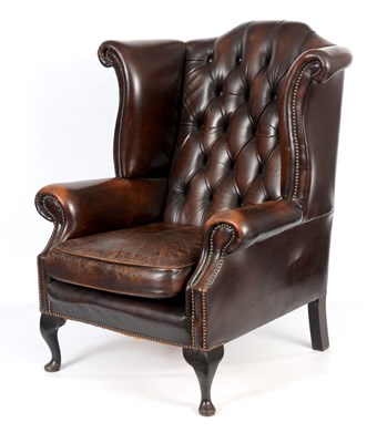 Lot 1013 - A 19TH CENTURY STYLE BUTTONED BROWN LEATHERED WINGED ARMCHAIR