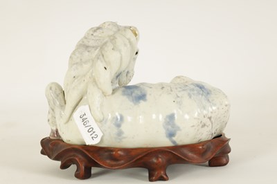 Lot 69 - A 19TH CENTURY CHINESE POTTERY WHITE AND BLUE SPASH GLAZED SCULPTURE OF A RECUMBENT HORSE