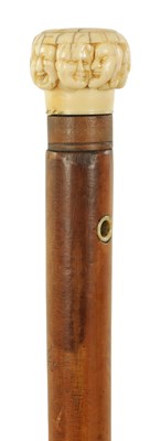 Lot 346 - A 19TH CENTURY CARVED IVORY AND MALACA ‘SEVEN FACES’ WALKING STICK
