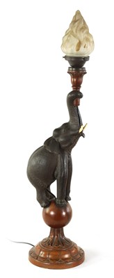 Lot 546 - A STYLISH EARLY 20TH CENTURY AESTHETIC CARVED WALNUT AND EBONISED TABLE LAMP MODELLED AS AN ELEPHANT STANDING ON A BALL