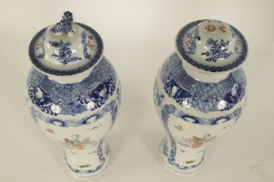 Lot 184 - A PAIR OF 19TH CENTURY CHINESE FAMILLE ROSE BLUE AND WHITE SLENDER INVERTED BALUSTER VASES AND COVERS