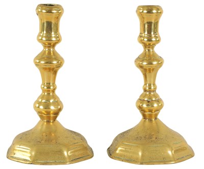 Lot 411 - A PAIR OF 18TH CENTURY CAST BRASS CANDLESTICKS