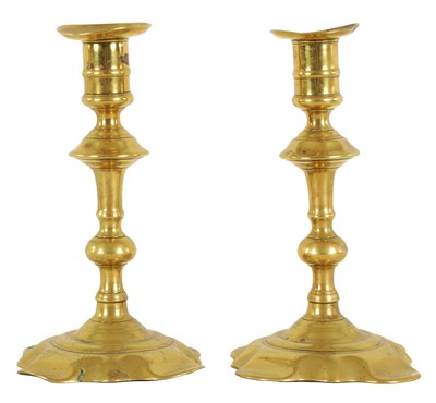 Lot 413 - A PAIR OF EARLY GEORGIAN CAST BRASS CANDLESTICKS