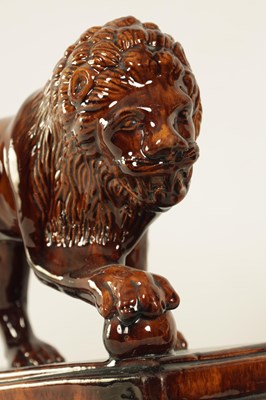 Lot 33 - A GOOD PAIR OF 19TH CENTURY TREACLE GLAZED TERRACOTTA MEDICI LIONS