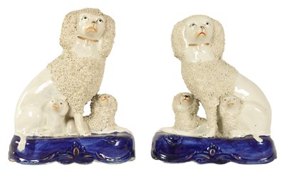 Lot 1224 - A PAIR OF 19TH CENTURY STAFFORDSHIRE SEATED POODLE DOGS WITH PUPS