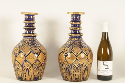 Lot 9 - A LARGE PAIR OF 19TH CENTURY BOHEMIAN CUT GILT AND BRISTOL BLUE SERVING BOTTLES