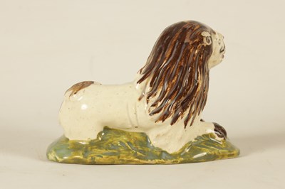 Lot 32 - AN EARLY 19TH CENTURY STAFFORDSHIRE SCULPTURE OF A RECUMBENT LION
