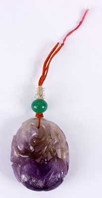 Lot 122 - AN EARLY 20TH CENTURY CARVED AMETHYST PENDANT...