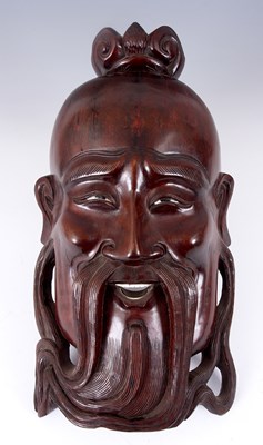 Lot 102 - AN ORIENTAL CARVED HARDWOOD MASK OF A DEITY...