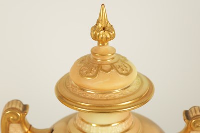 Lot 52 - AN ORNATE ROYAL WORCESTER GILT AND IVORY GROUND SCROLLED TWO-HANDLED CABINET VASE AND COVER