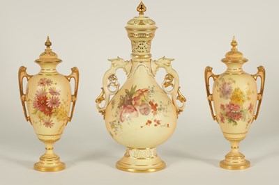 Lot 52 - AN ORNATE ROYAL WORCESTER GILT AND IVORY GROUND SCROLLED TWO-HANDLED CABINET VASE AND COVER