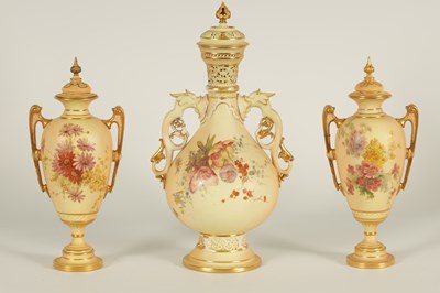 Lot 77 - AN ORNATE ROYAL WORCESTER GILT AND IVORY GROUND SCROLLED TWO-HANDLED CABINET VASE AND COVER