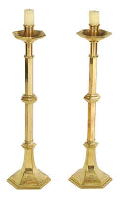 Lot 532 - A PAIR OF ARTS AND CRAFTS STYLE GOTHIC CAST BRASS CANDLESTICKS