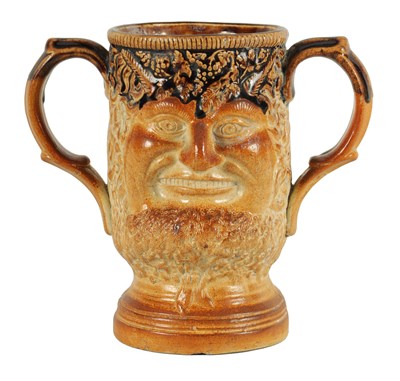 Lot 56 - AN UNUSUAL 19TH CENTURY DOULTON TYPE SALT GLAZED STONEWARE DOUBLE SIDED TWO HANDLED MASK HEAD LOVING CUP