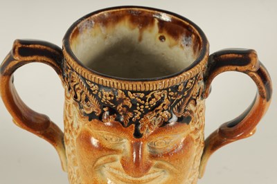 Lot 56 - AN UNUSUAL 19TH CENTURY DOULTON TYPE SALT GLAZED STONEWARE DOUBLE SIDED TWO HANDLED MASK HEAD LOVING CUP