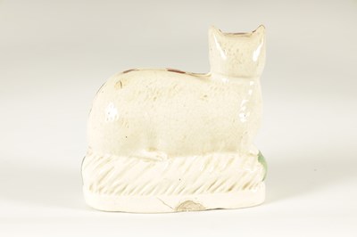 Lot 67 - AN EARLY 19TH CENTURY STAFFORDSHIRE MODEL ON A RECUMBENT CAT