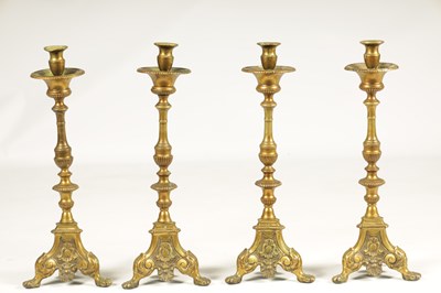 Lot 501 - A SET OF FOUR 18TH CENTURY CONTINENTAL LARGE BRASS CANDLESTICKS