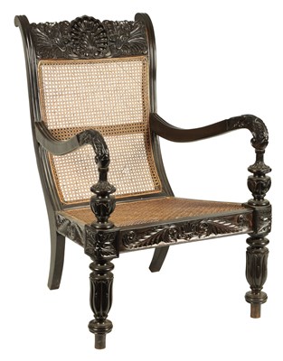 Lot 227 - AN IMPRESSIVE LATE REGENCY ANGLO INDIAN CARVED EBONY BERGERE OPEN ARMCHAIR OF GENEROUS SIZE