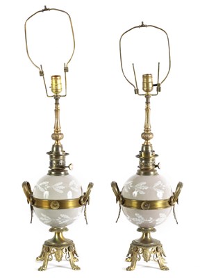 Lot A PAIR OF LATE 19TH CENTURY CAST GILT BRASS AND PORCELAIN OIL LAMPS CONVERTED FOR ELECTRICITY