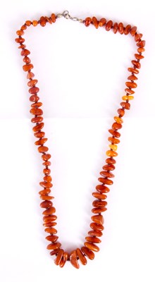 Lot 361 - AN AMBER BEAD NECKLACE on knotted brown string...