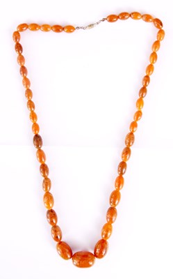 Lot 371 - AN AMBER BEAD NECKLACE on string and of...