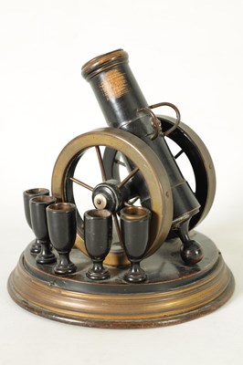 Lot 935 - A 19TH CENTURY EBONISED AND BRASS MOUNTED NOVELTY CIGAR AND MATCH HOLDER FORMED AS A CANNON