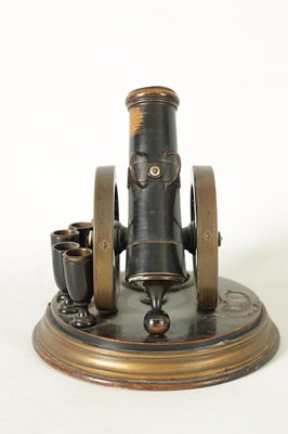 Lot 935 - A 19TH CENTURY EBONISED AND BRASS MOUNTED NOVELTY CIGAR AND MATCH HOLDER FORMED AS A CANNON