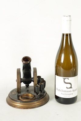 Lot 935 - A 19TH CENTURY EBONISED AND BRASS MOUNTED NOVELTY CIGAR AND MATCH HOLDER FORMED AS A CANNON