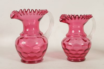 Lot 5 - A GRADUATED PAIR OF 19TH CENTURY STYLE OVERSIZED CRANBERRY GLASS JUGS