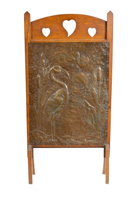 Lot 565 - AN ARTS AND CRAFTS PRESSED BRASS AND OAK FIRE SCREEN