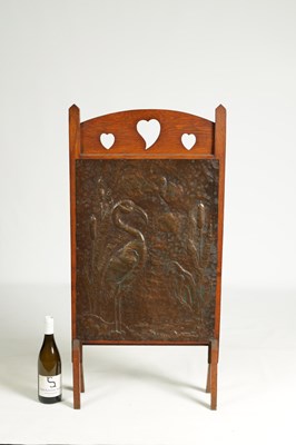 Lot 920 - AN ARTS AND CRAFTS PRESSED BRASS AND OAK FIRE SCREEN
