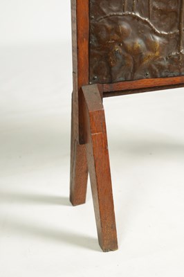 Lot 920 - AN ARTS AND CRAFTS PRESSED BRASS AND OAK FIRE SCREEN