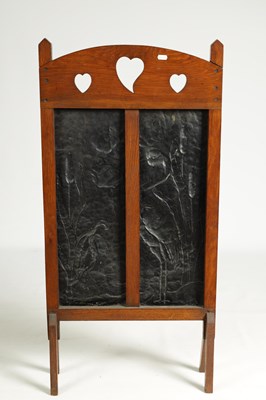 Lot 920 - AN ARTS AND CRAFTS PRESSED BRASS AND OAK FIRE SCREEN