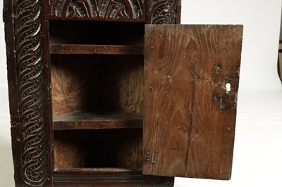 Lot 1025 - A 17TH-CENTURY SMALL CARVED OAK HANGING CORNER CUPBOARD