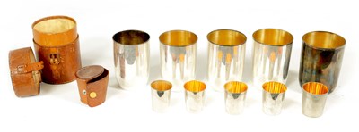 Lot 270 - A GEORGE V BROWN LEATHER CASED FITTED TRAVELLING SET OF FIVE SILVER BEAKERS