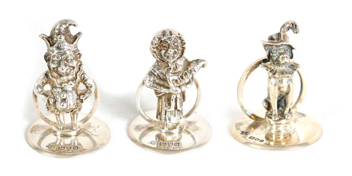 Lot 352 - A SET OF THREE CAST SILVER FIGURAL MENU HOLDERS OF PUNCH AND JUDY AND DOG