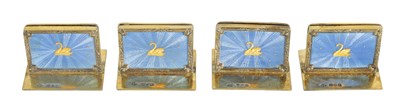 Lot 479 - A CASED SET OF FOUR SILVER GILT AND BLUE GUILLOCHE ENAMEL MENU HOLDERS